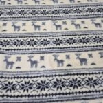 Naturalny koc 100% owczej wełny, biały w szare pasy z reniferami. Ręcznie wykonany w Polsce, ciepły i przytulny. Rozmiar 215×200 cm – idealny na zimę i Święta.